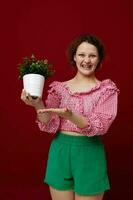 bonito mujer en rosado blusa flor en conserva emociones posando inalterado foto