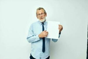 Portrait of happy senior man in a shirt with a tie copy-space sheet of paper cropped view photo