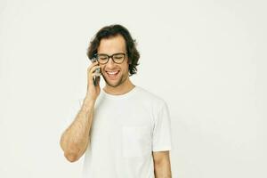 hermoso hombre en un blanco camiseta comunicación por teléfono aislado antecedentes foto