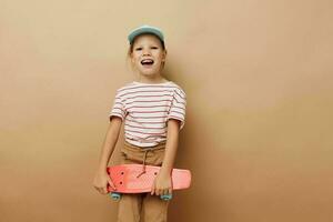 little girl skateboard in hand posing baby clothes fun isolated background photo