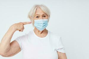 emotional elderly woman respiratory protection light background photo