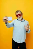 Portrait elderly man blue shirts with glasses takes a selfie unaltered photo