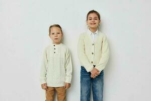 two little girls in sweaters posing childhood light background photo