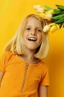 cute little girl with blond hair a bouquet of yellow flowers photo