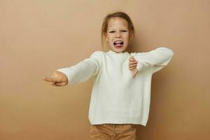 pequeño niña en blanco suéter posando mano gestos estilo de vida inalterado foto