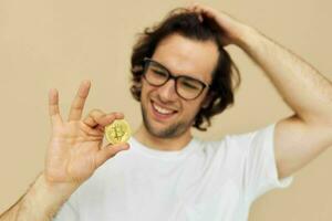 hombre en un blanco camiseta con bitcoin criptomoneda beige antecedentes foto