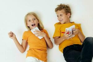 Boy and girl drawing in notebooks lying on the floor childhood lifestyle unaltered photo