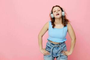 retrato de linda joven niña en auriculares escuchando a música rosado antecedentes inalterado foto