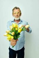 antiguo hombre un ramo de flores de flores con lentes como un regalo ligero antecedentes foto