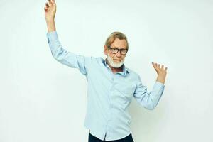 Senior grey-haired man in blue shirts gestures with his hands isolated background photo