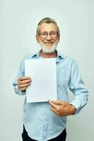 Portrait elderly man holding a sheet of paper copy-space posing cropped view photo