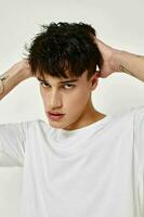 handsome guy modern youth style white t-shirt tattoo on the arm isolated background unaltered photo