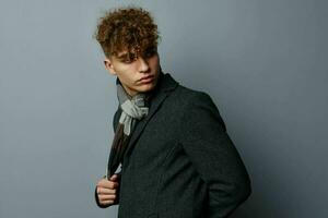 handsome guy in a coat a checkered scarf isolated background photo