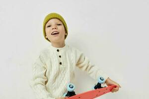 little girl in hats with a skateboard in their hands light background photo