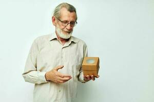 antiguo hombre con lentes demuestra un caja en estudio uno foto