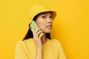 encantador joven asiático mujer hablando en el teléfono posando Moda aislado antecedentes inalterado foto