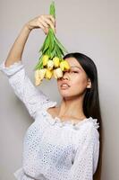 Charming young Asian woman with a bouquet of flowers smile close-up isolated background unaltered photo