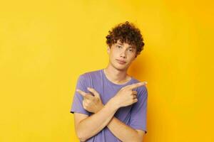 guy with curly hair in purple t-shirts studio yellow background photo