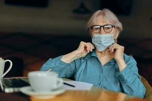 Senior woman sitting in a cafe with a cup of coffee and a laptop Retired woman chatting unaltered photo