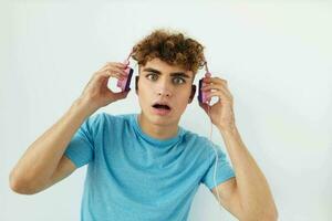 atractivo hombre en rosado auriculares música emociones aislado antecedentes foto