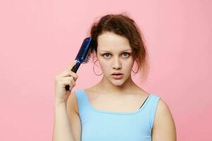 portrait of a woman in blue t-shirts comb with hair emotions isolated background unaltered photo