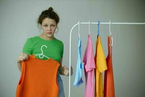 portrait of a young woman ironing clothes on a hanger wardrobe light background unaltered photo