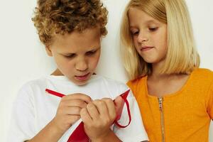 imagen de positivo chico y niña divertido en vistoso camisetas con un bloc aislado antecedentes inalterado foto