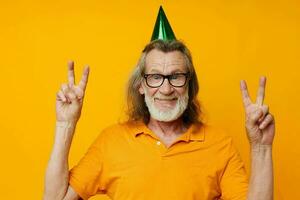 Senior grey-haired man fun birthday cap on the head isolated background photo