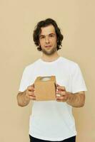 cheerful man in a white t-shirt with a cardboard box in his hands photo