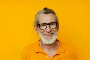 an elderly man with glasses in a yellow t-shirt with glasses close-up photo