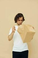 Attractive man in a white T-shirt with paper bag isolated background photo