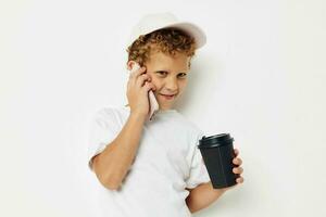 Photo portrait curly little boy what kind of drink is the phone in hand communication isolated background unaltered