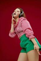 cheerful girl in a pink shirt listening to music on headphones unaltered photo