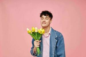 portrait of a young man in a denim jacket with a bouquet of flowers a gift romance holiday unaltered photo