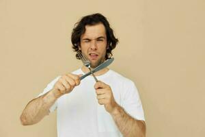 Attractive man in a white T-shirt with knife with fork Lifestyle unaltered photo