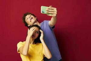 a young couple modern style emotions fun phone red background photo