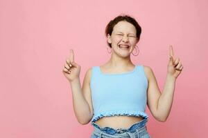 pretty girl blue t shirt hand gestures emotion pink background unaltered photo