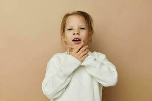 pretty young girl in white sweater posing hand gestures beige background photo