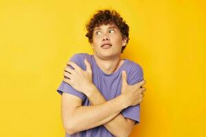 guy with curly hair in purple t-shirts studio yellow background photo