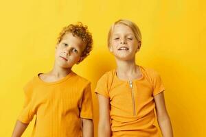 linda elegante niños casual vestir juegos divertido juntos posando en de colores antecedentes inalterado foto