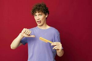 portrait of a young curly man posing hairbrush personal care Youth style photo