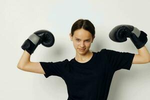 athletic woman in boxing gloves in black pants and a T-shirt fitness training photo