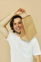 Attractive man in a white T-shirt with paper bag isolated background photo