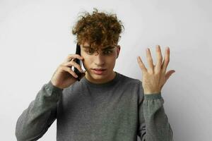 hermoso joven hombre mirando a el teléfono Moda ligero antecedentes foto