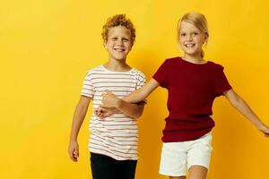 Small children casual wear games fun together yellow background photo