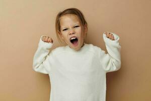 linda niña en blanco suéter posando mano gestos infancia inalterado foto