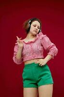 cheerful girl in a pink shirt listening to music on headphones unaltered photo