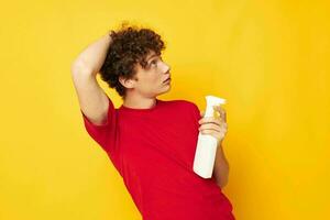 guy with red curly hair in a red t-shirt detergents in hands posing Lifestyle unaltered photo