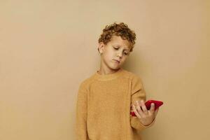 boy in a sweater with a phone in his hands technology beige background photo