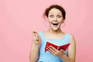 Young woman writing in a red notebook with a pen study Lifestyle unaltered photo